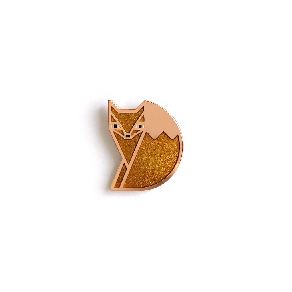 Foxsimile orange enamel fox pin in copper with sly eyes and a bushy tail.