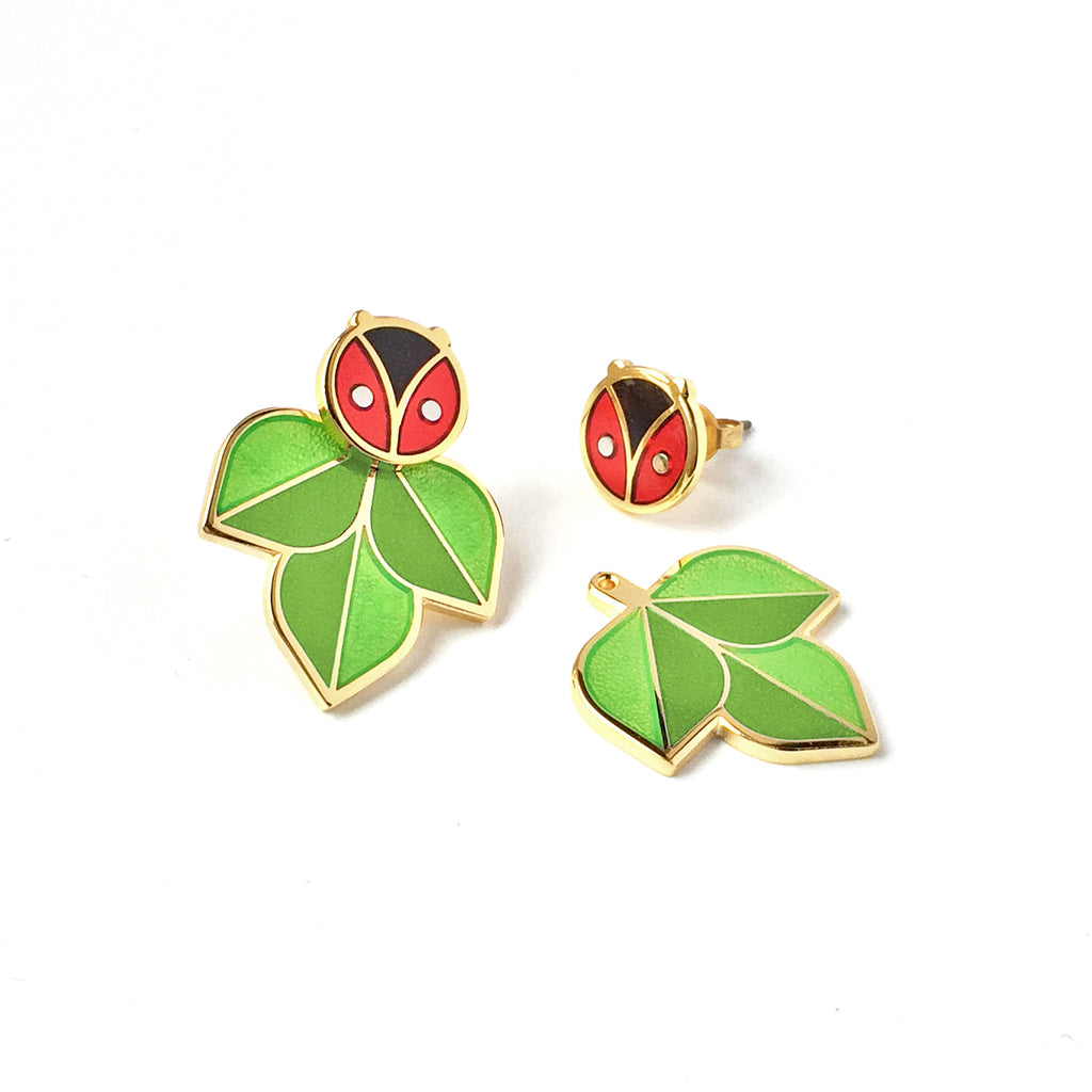 Coccinella red and black enamel ladybug or ladybird studs with two tone green leaf jackets in silver and 24k gold.