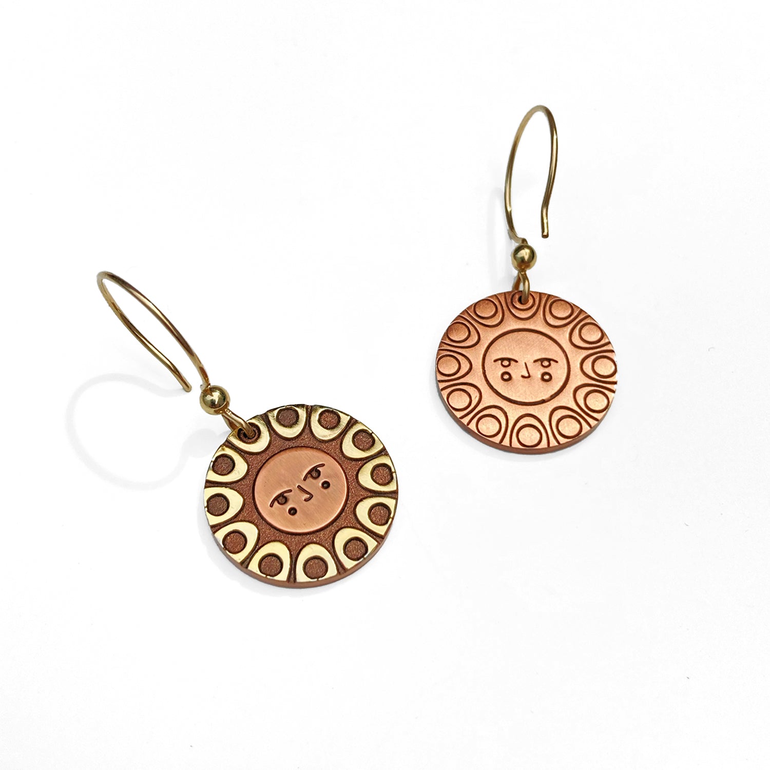 Reverse detail: Helios solar earrings finished in 24k gold and antique copper. Shows a classic sun face relief back detail.