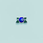 Small blue and green blueberry enamel pin on a light blue background