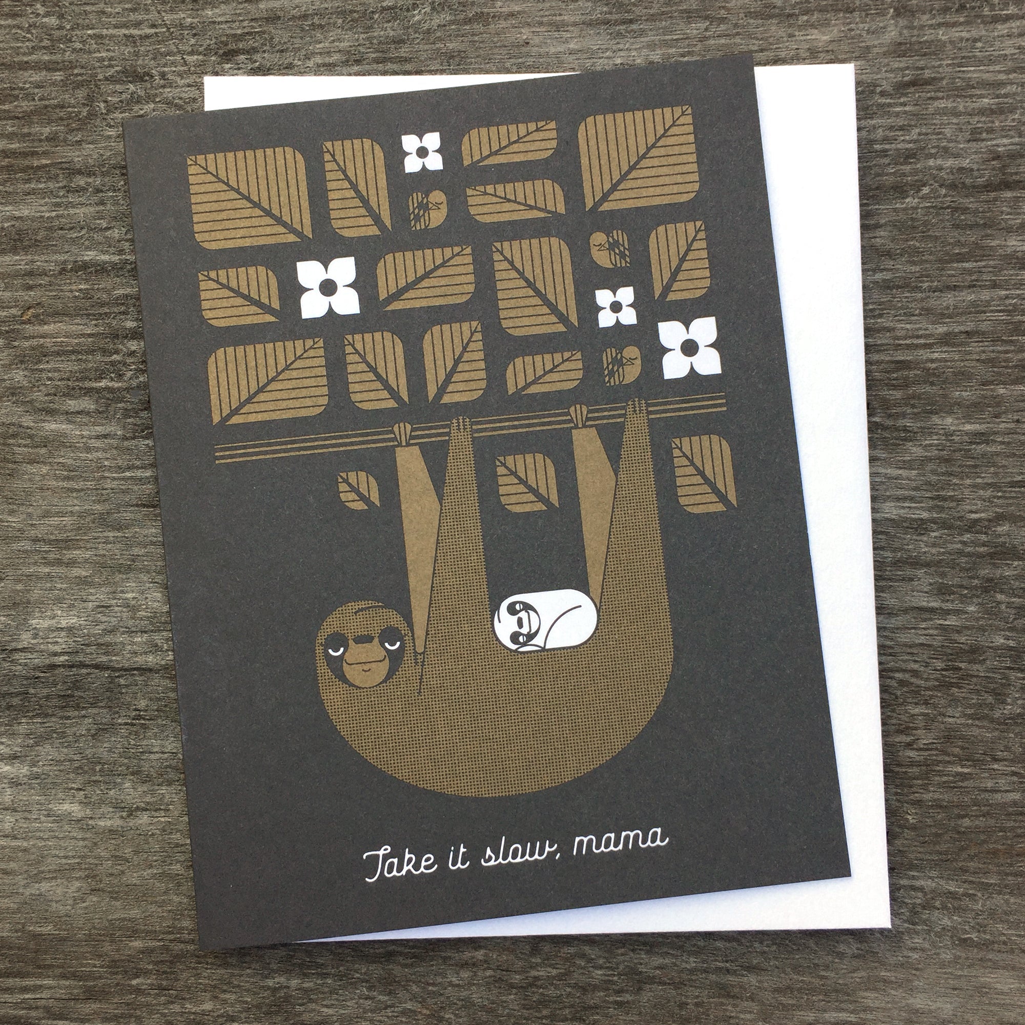 Take It Slow, Mama greeting card in brown and black. Shows a sloth with her cub hanging from a tree branch with leaves.