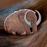Woolly Mammoth enamel pin in silver with translucent brown enamel.