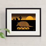 Karmadillo screen print in orange and black of a nine banded armadillo with pups and saguaro cactus during a desert sunset.