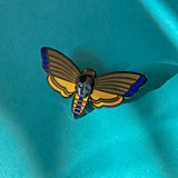 Atropos enamel death's-head moth pin in black seconds with black mirrored siofourite crystal skull.