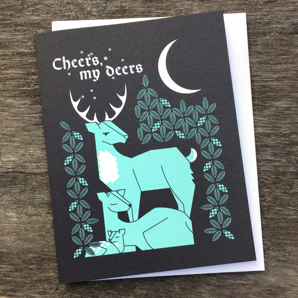 Cheers, My Deers greeting card in light blue and black shows a buck watching over a doe and fawn under a night sky.