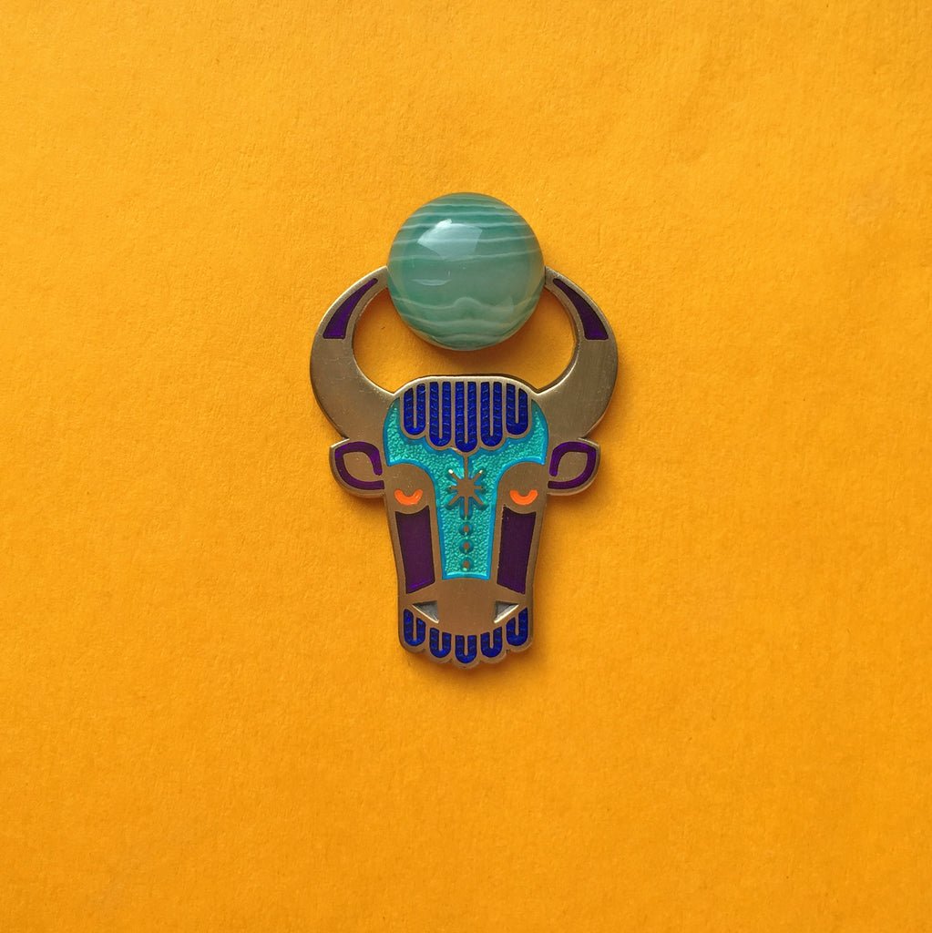 Enzu enamel bull or taurus pin in antique gold, with green agate cabochon between its horns.