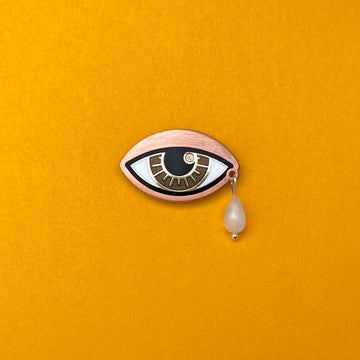 Ersa chestnut brown enamel eye pin in gold and antique copper with a rainbow moonstone teardrop.