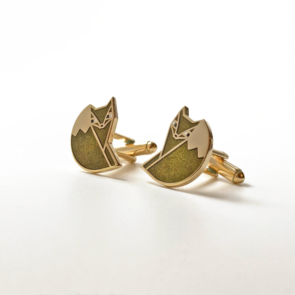 A pair of Foxsimile light grey enamel sly fox cufflinks with 24k gold finish.