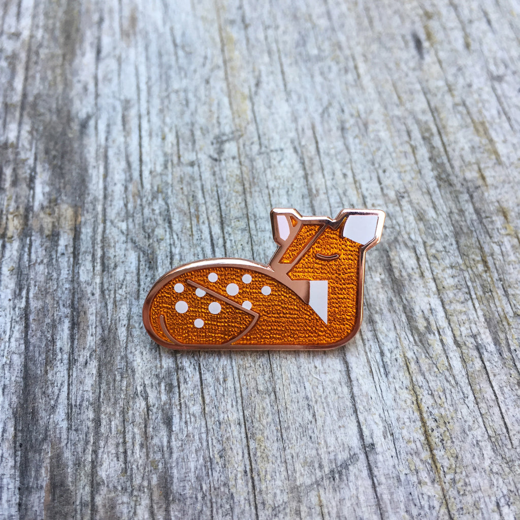 Goldie Fawn orange enamel deer pin in copper. Depicts a spotted fawn napping.