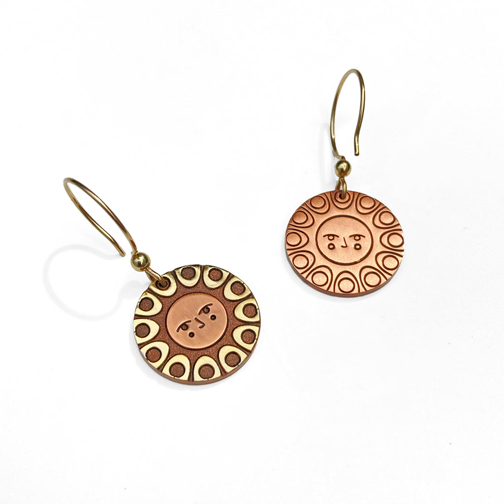 Reverse detail: Helios solar earrings finished in 24k gold and antique copper. Shows a classic sun face relief back detail.