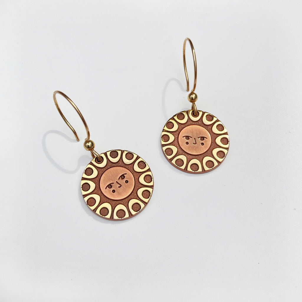 Helios solar earrings seconds finished in 24k gold and antique copper. Shows a classic sun with face on french hooks.