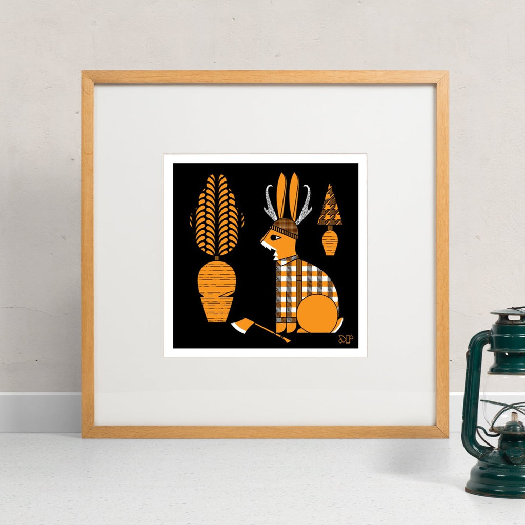 Lumberjackalope screen print in orange and black. Depicts a lumberjack jackalope cutting carrots. Shown framed and hung.