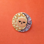 Illumine solar and lunar enamel pin in gold and silver. With a classic sun face and sleeping moon.
