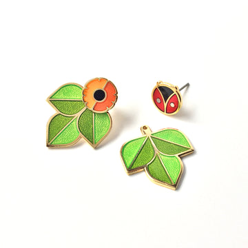 Cross Pollination Jacket Earrings with one each of anenome flower and coccinella studs and a pair of leaf ear jackets.