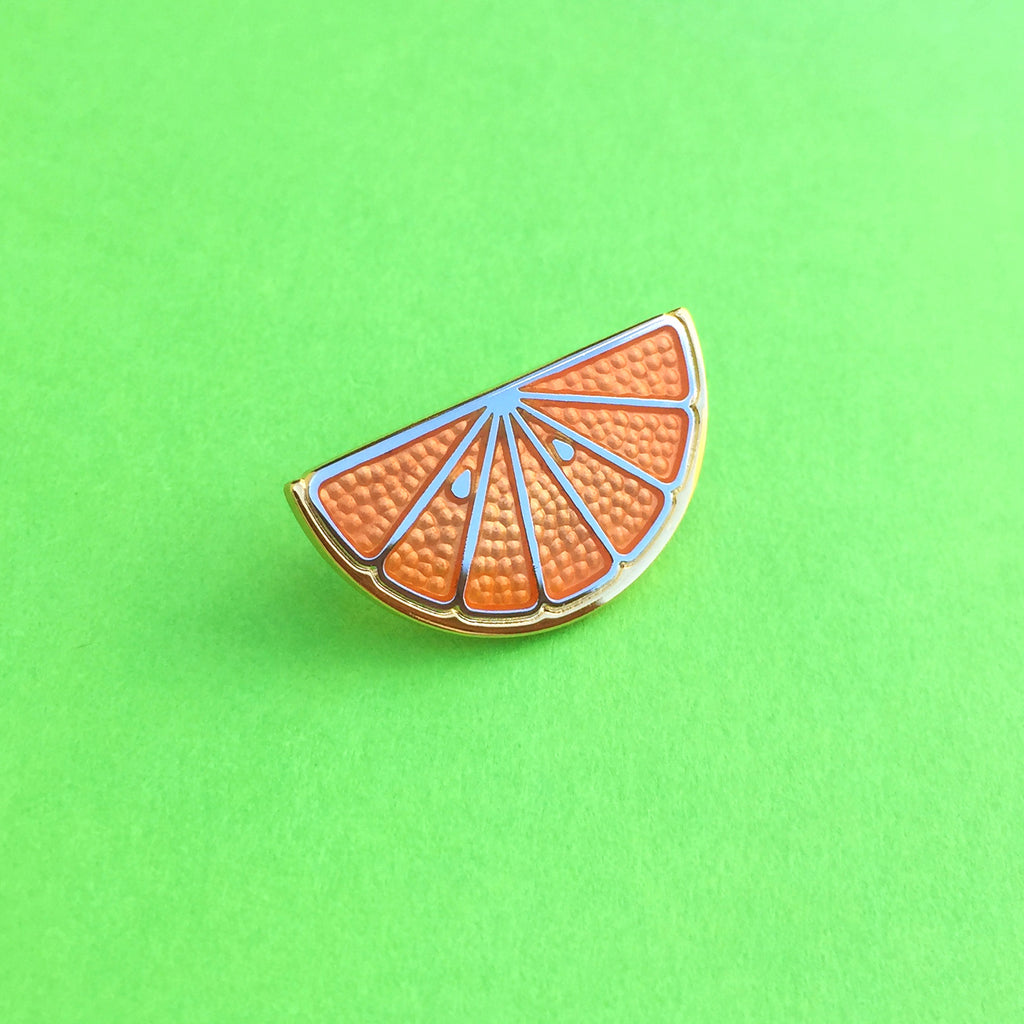 Clementine citrus orange enamel pin in gold and silver with translucent orange enamel.