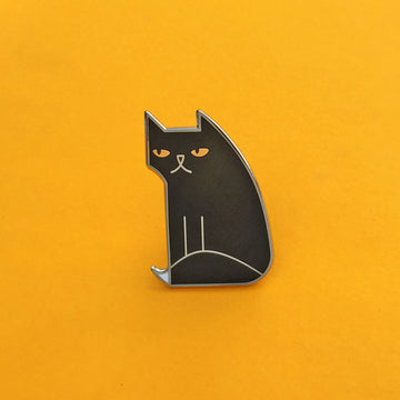 Not Amewsed black enamel cat pin seconds in silver, with gold eyes and white-tipped tail.