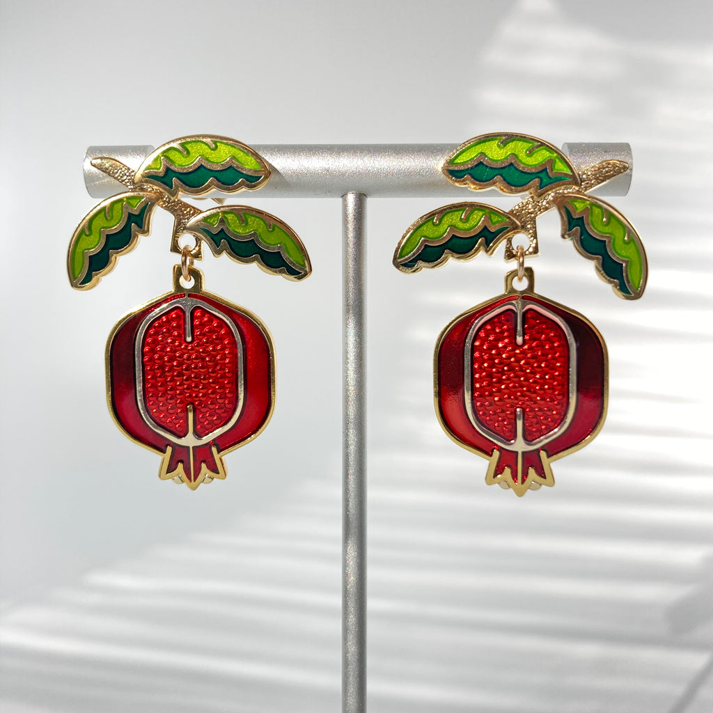 Pomegranate enamel earrings finished in 24k gold and sterling silver. Green leaf branch studs and red fruit dangle.