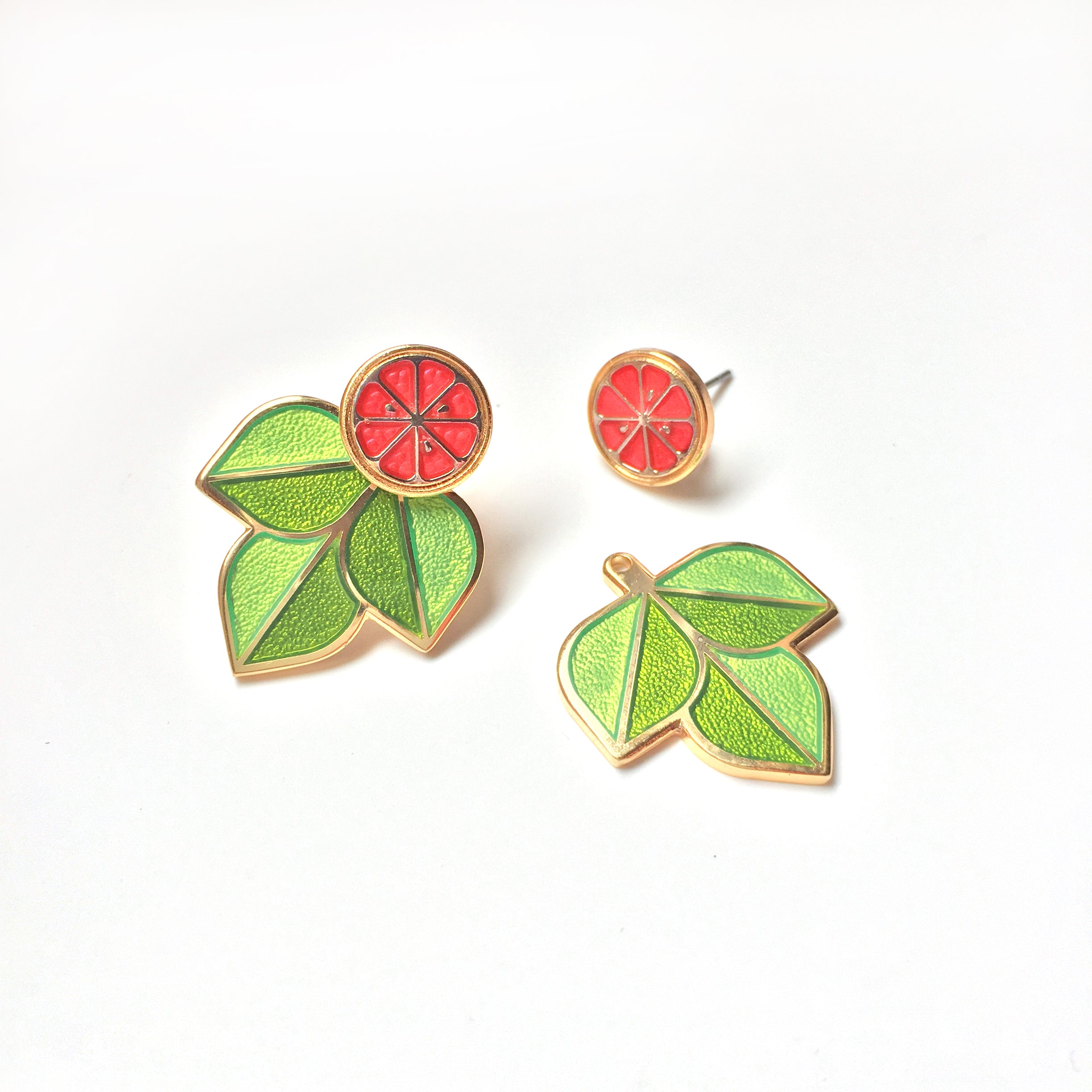 Ruby Red grapefruit earrings finished in 24k gold and sterling silver. Green enamel leaf ear jackets and sliced fruit studs.