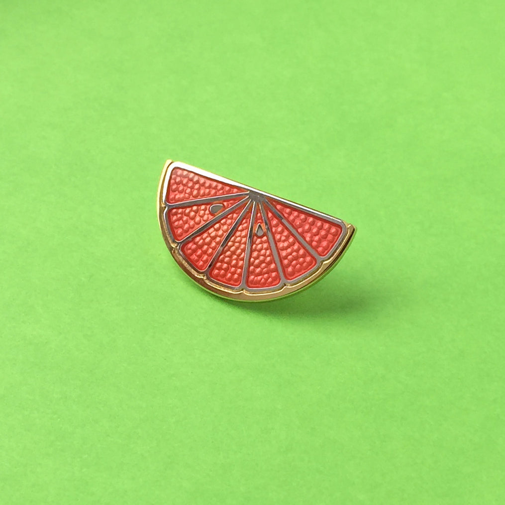 Ruby Red grapefruit red enamel pin in gold and silver. Half-circle fruit.