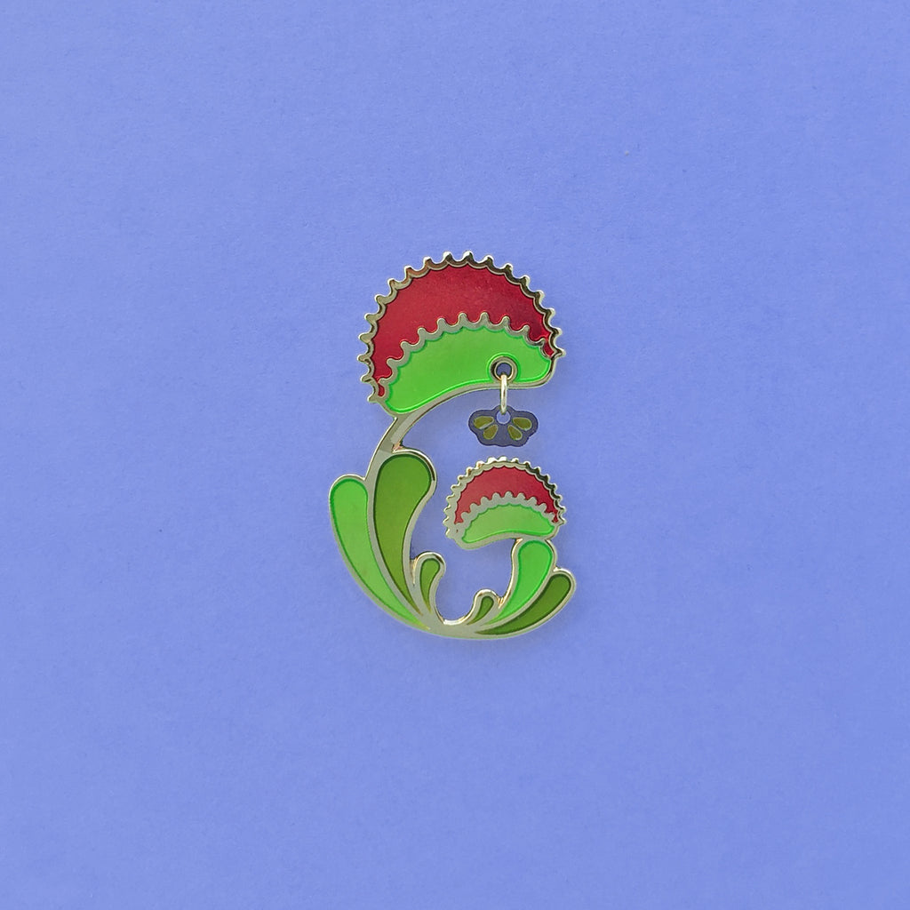 Venus Flytrap enamel pin. Dionaea muscipula in green, red and 24k gold finish. Fly dangle in silver and translucent wings.