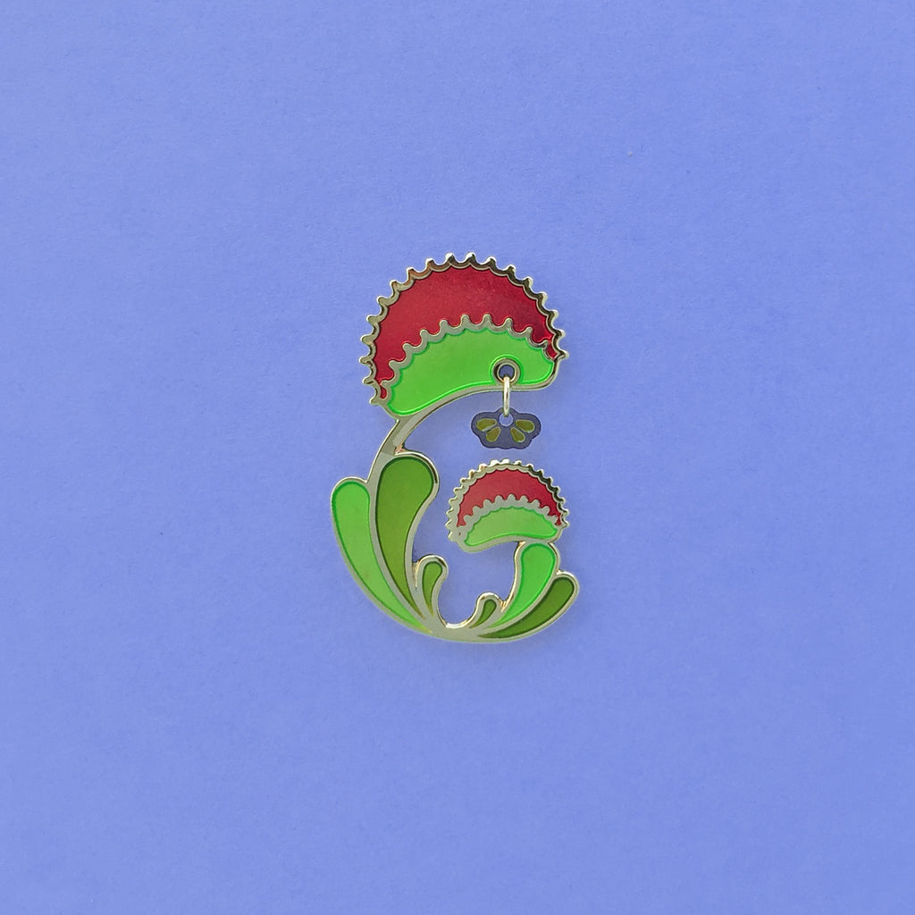Venus Flytrap enamel pin. Dionaea muscipula in green, red and 24k gold finish. Fly dangle in silver and translucent wings.