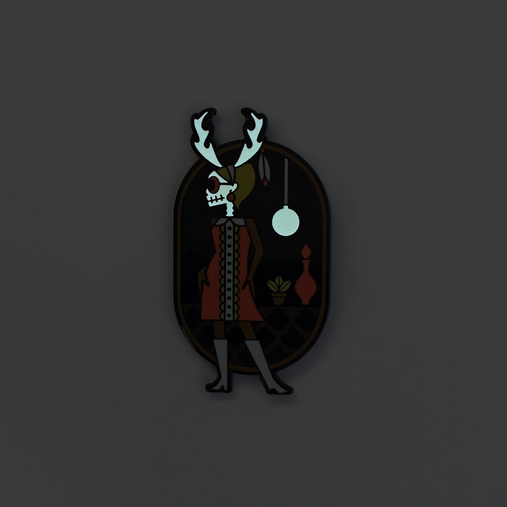 Wendigo-go enamel pin in black metal and fuchsia, black and green enamel. Shows glow in the skull and lamp.