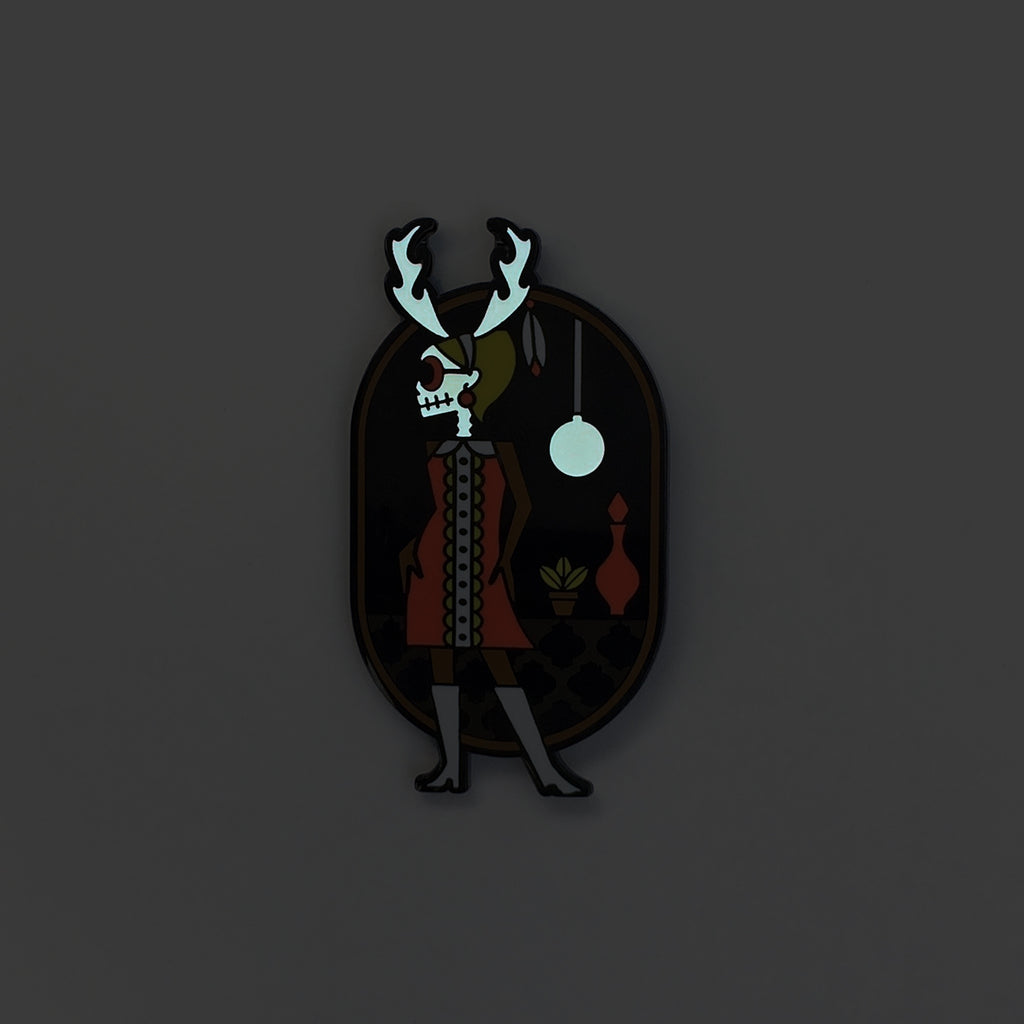 Wendigo-go enamel pin in black metal and fuchsia, black and green enamel. Shows glow in the skull and lamp.