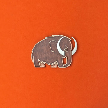 Woolly Mammoth enamel pin in silver with translucent brown enamel.